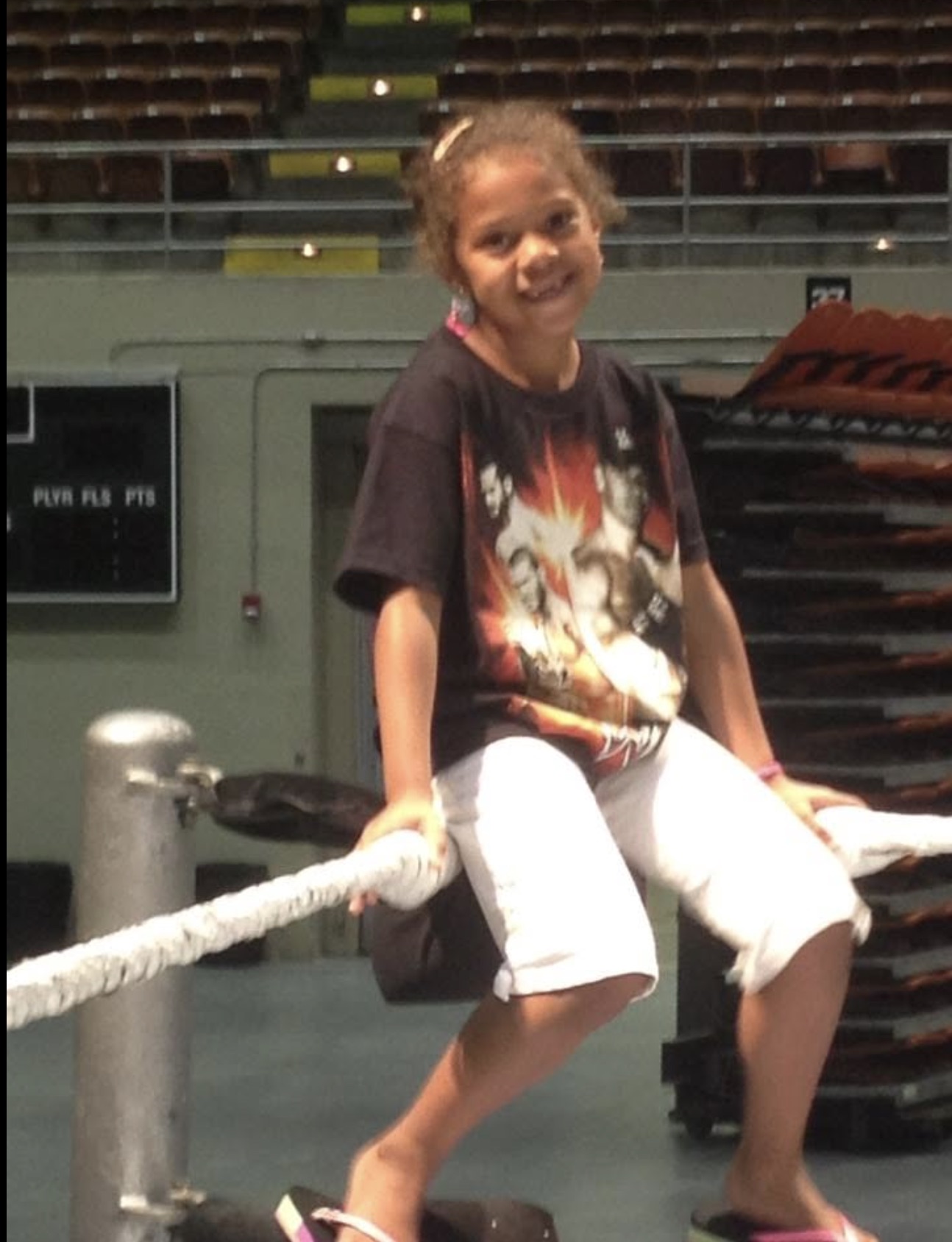 Kip's daughter sitting on the bottom rope in an empty arena