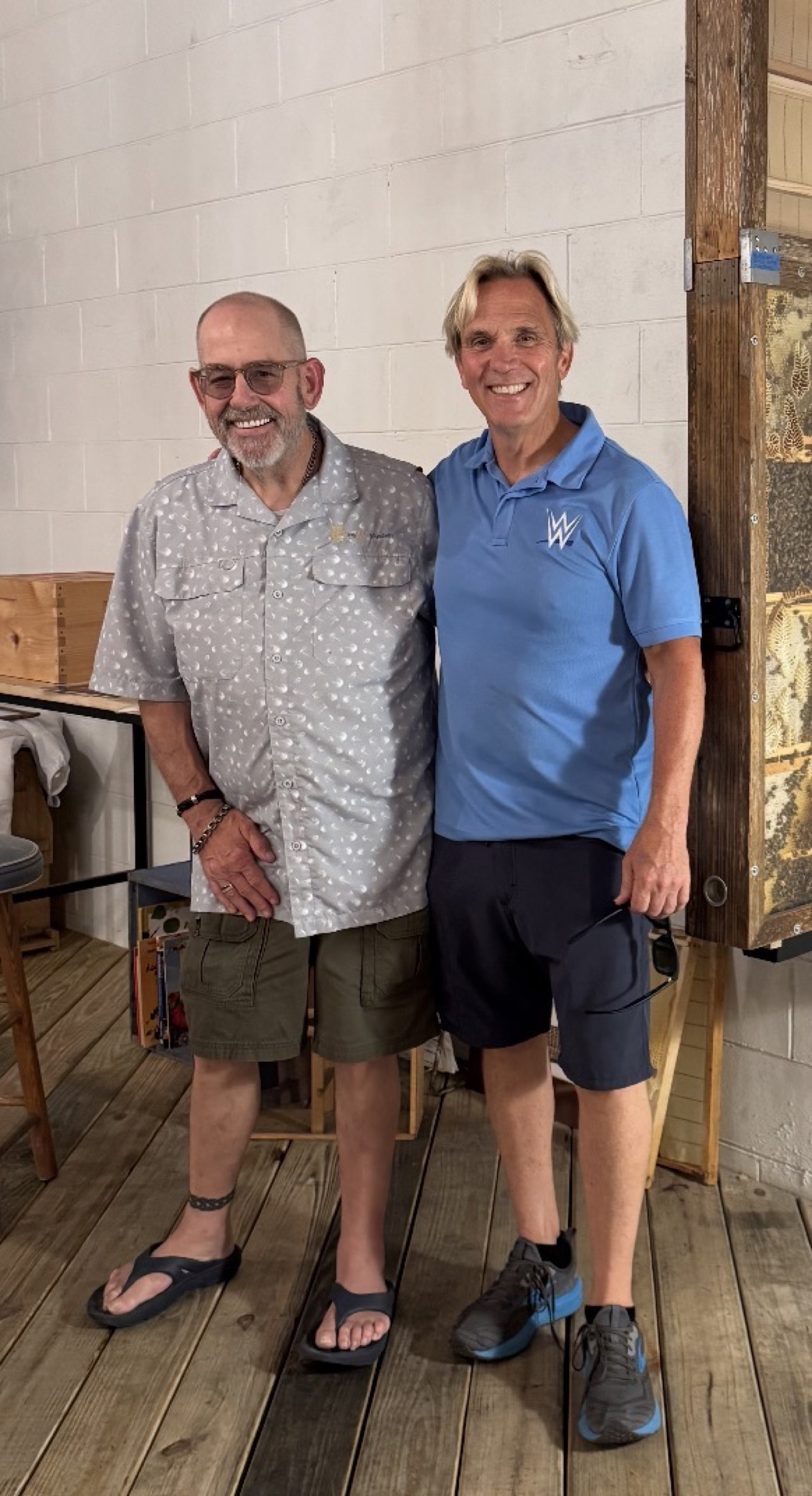 Charles Robinson and Kip Lee standing together at Savannah Bee Company with an observation beehive on the wall, August 2026